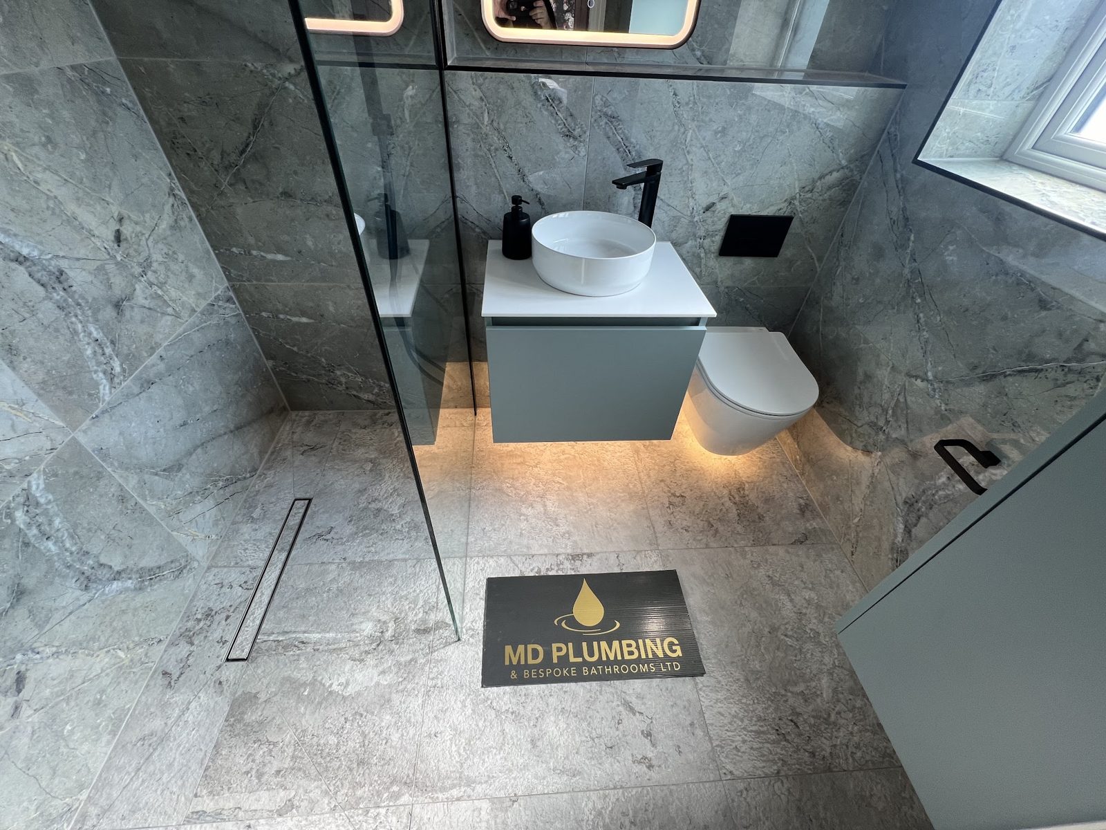 Grey marble walk-in shower room with a wall-hung toilet and floating basin